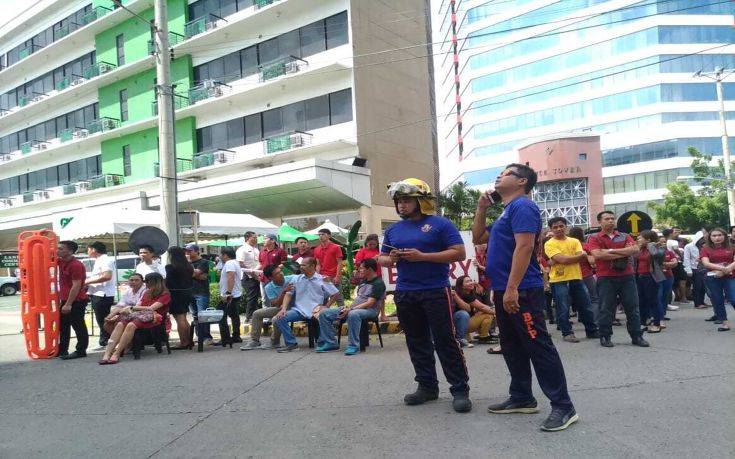 Office employees gather outside of buildings after a powerful earthquake was felt in Davao City, Philippines Tuesday, Oct. 29, 2019. A  powerful earthquake shook the southern Philippines on Tuesday morning, but no damage or casualties were immediately reported. (AP Photo)