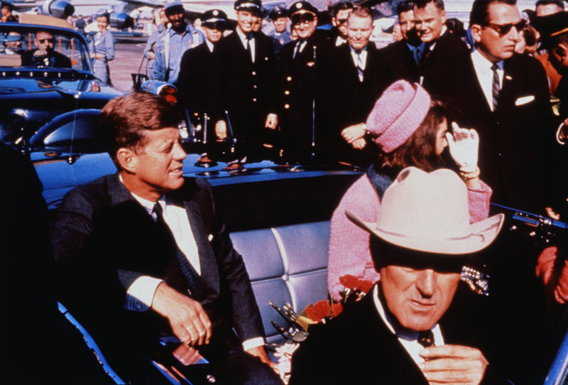(Original Caption) Texas Governor John Connally adjusts his tie (foreground) as President and Mrs. Kennedy, in a pink outfit, settled in rear seats, prepared for motorcade into city from airport, Nov. 22. After a few speaking stops, the President was assassinated in the same car.