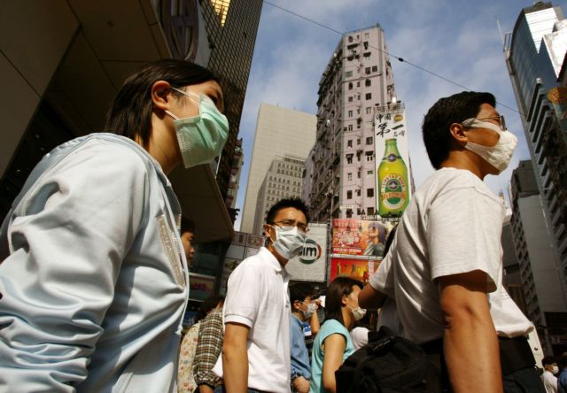 Shoppers wear masks to protect themselves against the flu-like Severe Acute Respiratory Syndrome (SARS) in Hong Kong's Causeway Bay shopping district in this April 21, 2003 file photo. Picture taken April 21, 2003.  To match Special Report SAUDI-MERS    REUTERS/Bobby Yip/Files   (CHINA - Tags: HEALTH SOCIETY)