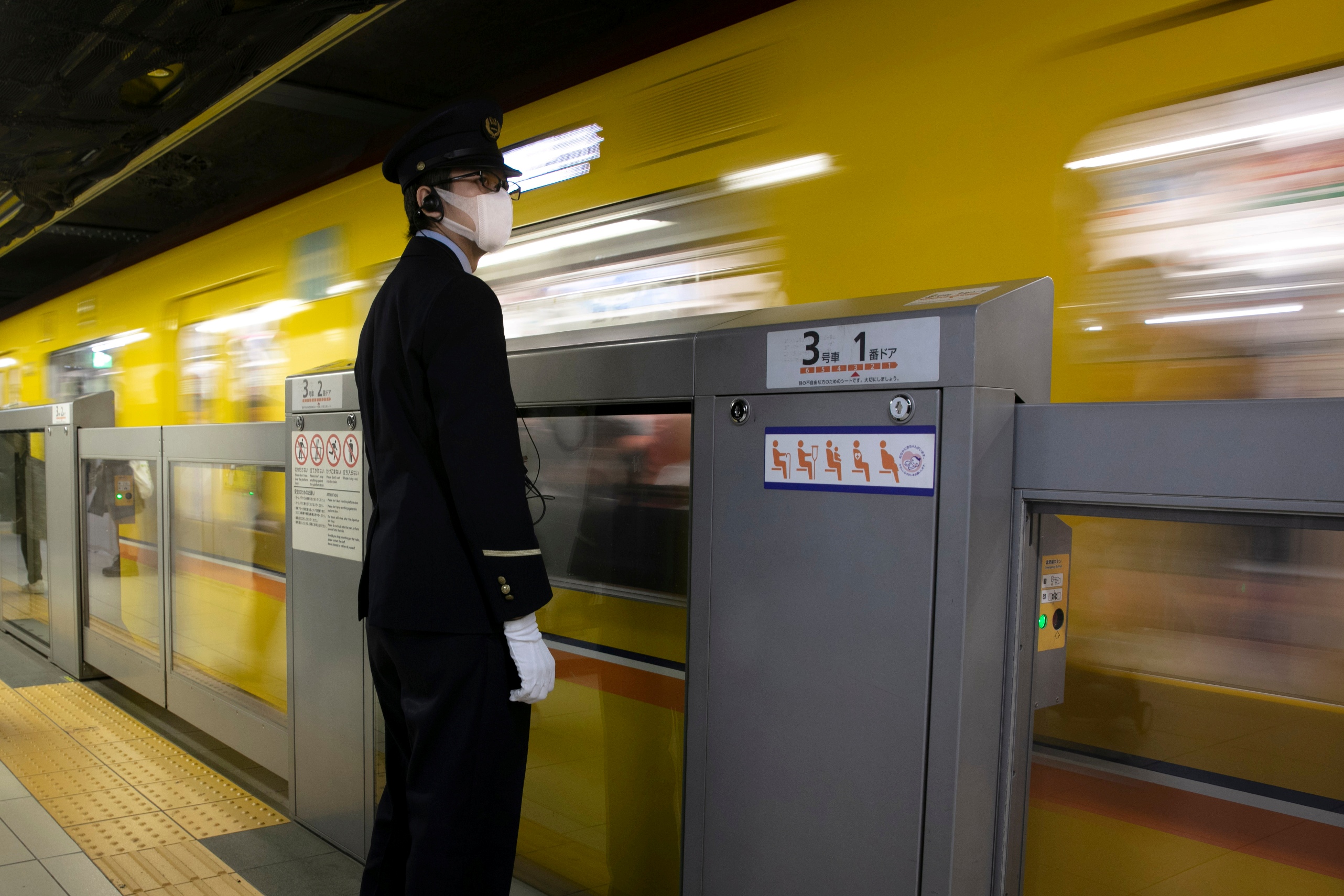 A station attendant wearing a mask stands on a platform as a train departs from Ginza Station in Tokyo Thursday, Jan. 30, 2020. (AP Photo/Jae C. Hong)