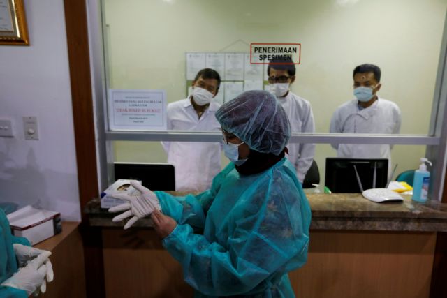 Journalists wear protective suits during a media visit to Indonesian Health Ministry's Laboratorium for Research on Infectious-Diseases, following the outbreak of the new coronavirus in China, in Jakarta, Indonesia, February 11, 2020. REUTERS/Willy Kurniawan  REFILE - CORRECTING DATE