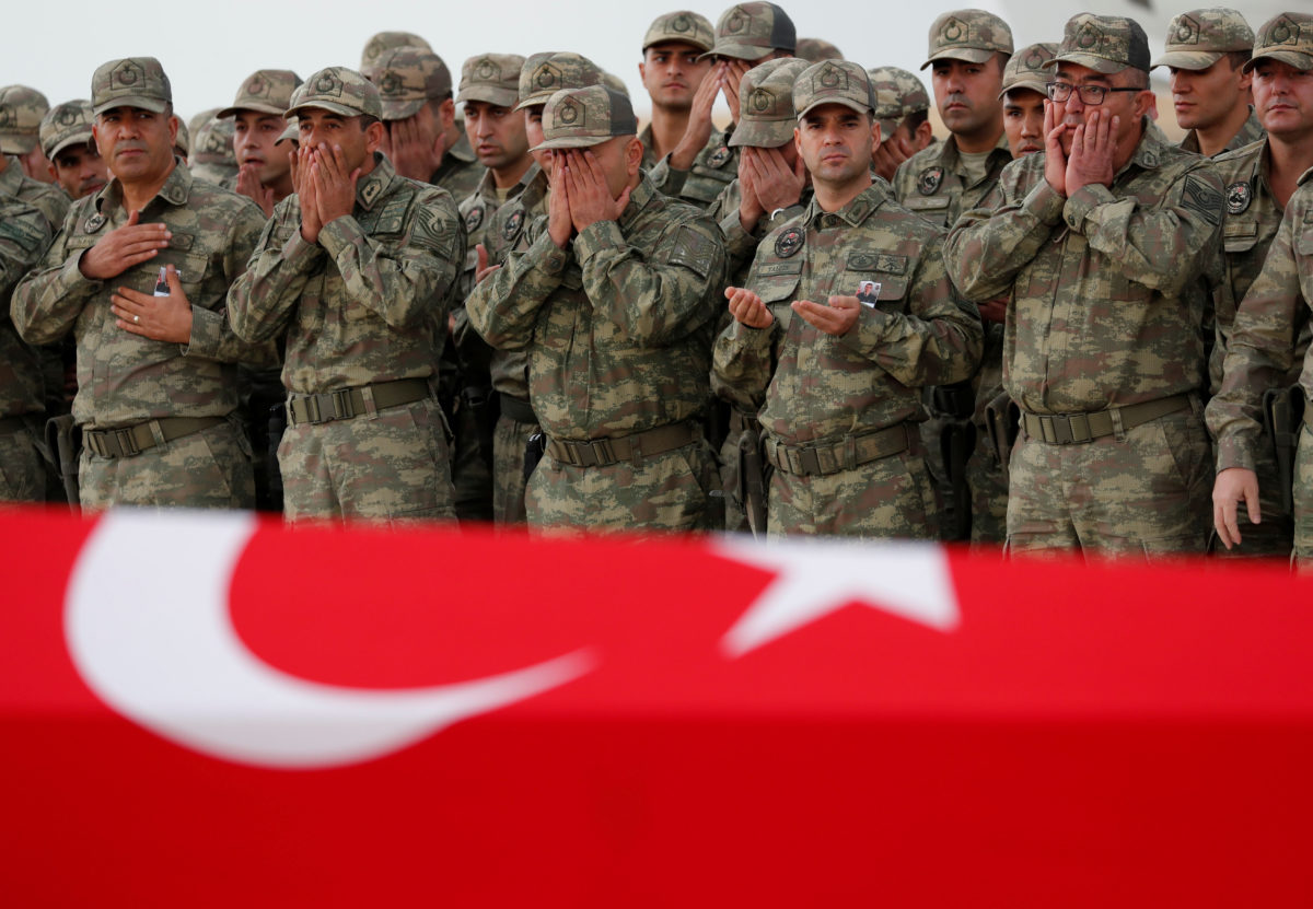 Turkish soldiers pray before the flag-wrapped coffin of their comrade Sefa Findik, who was killed in the military operation in northeast Syria, during a ceremony at the GAP Airport in Sanliurfa, Turkey, October 20, 2019. REUTERS/Murad Sezer