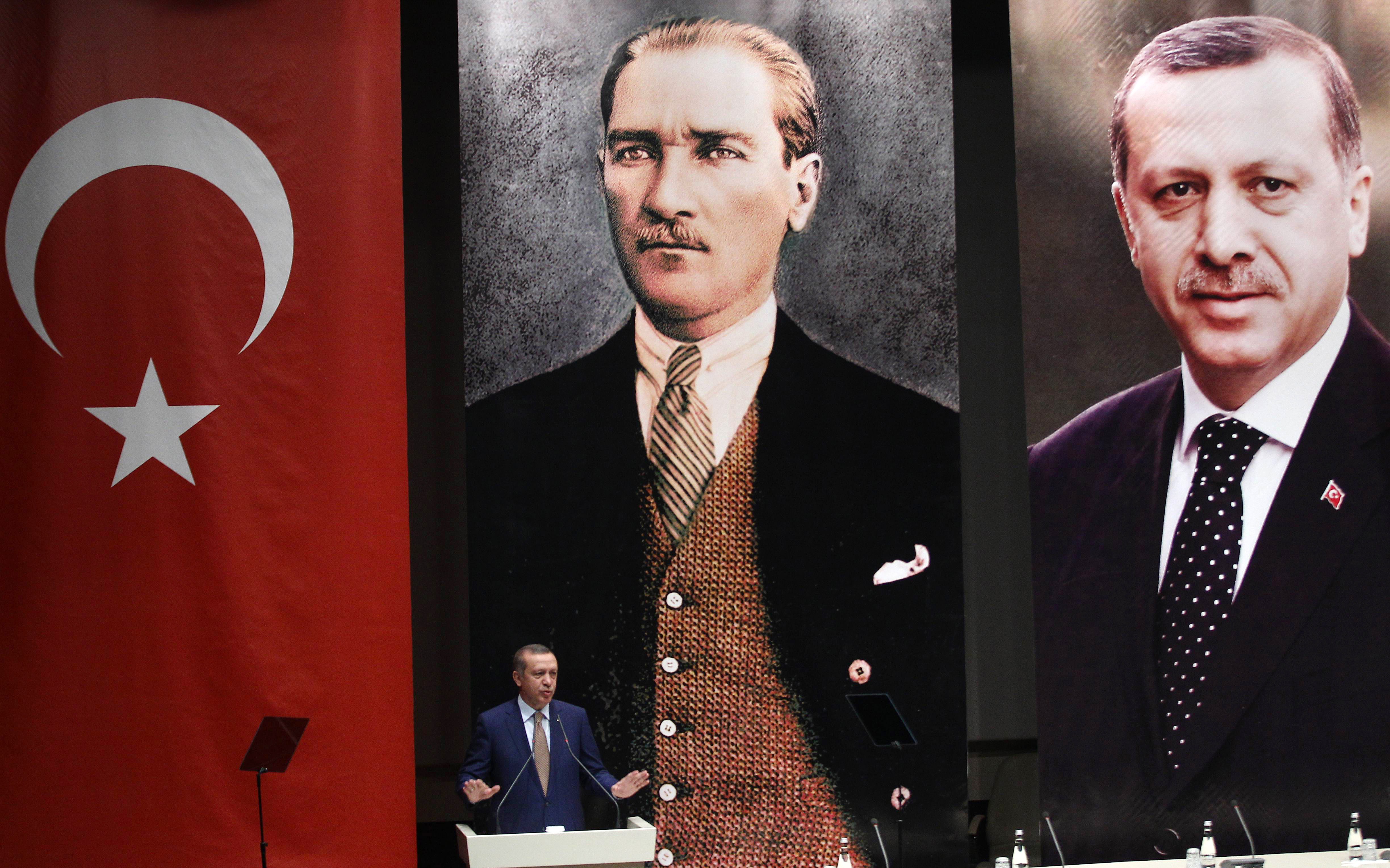 Turkey's Prime Minister Recep Tayyip Erdogan addresses members of his ruling AK Party, as he stands in front of portraits of himself (R) and Mustafa Kemal Ataturk, the founder of modern Turkey, during a meeting at his party headquarters in Ankara on May 23, 2014. AFP PHOTO / ADEM ALTAN        (Photo credit should read ADEM ALTAN/AFP/Getty Images)