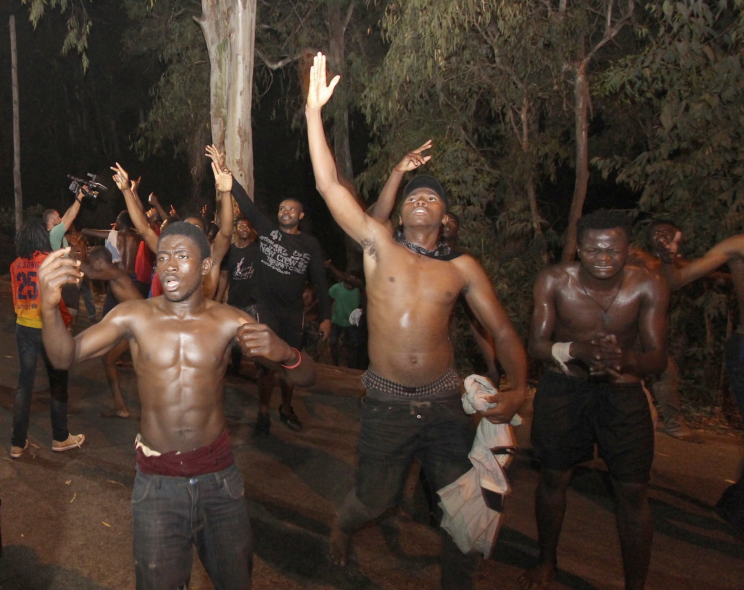 epa06129686 A group of sub-Saharan migrants celebrate after managing to enter Spanish territory in the city of Ceuta, Spanish enclave in northern Africa, early morning 07 August 2017. Some 200 migrants managed to cross the Spanish border, catching the Moroccan and Spanish security forces by surprise. Authorities were expecting the migrants to jump the fences, but the group entered Spain across the border crossing.  EPA/Reduan