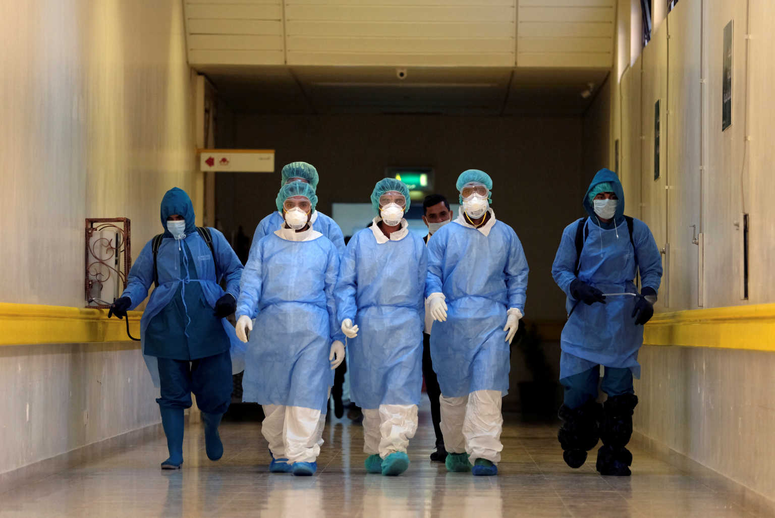 FILE PHOTO: Employees from a disinfection service company wearing protective face masks and gloves sanitise the corridors of Benghazi Medical Center following the outbreak of the coronavirus disease (COVID-19), in Benghazi, Libya April 14, 2020. REUTERS/Esam Omran Al-Fetori/File Photo
