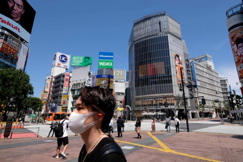 A man wearing a face mask amid concerns over the spread of the COVID-19 coronavirus crosses the Shibuya crossing in Tokyo on May 17, 2020. (Photo by Kazuhiro NOGI / AFP)