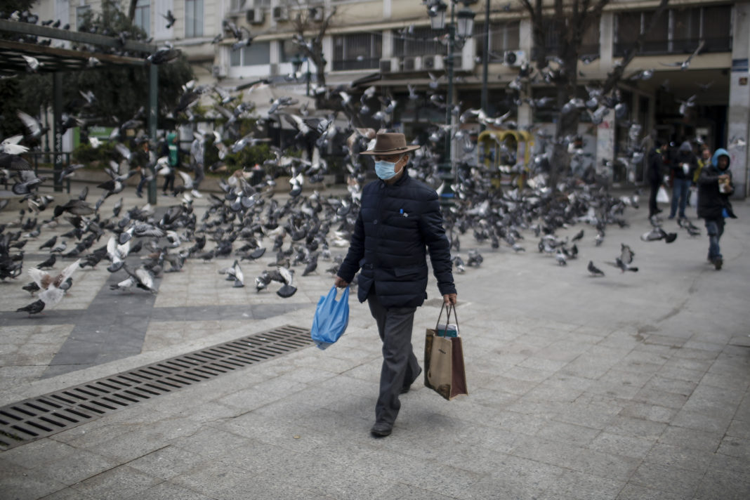 epa08298620 An elderly man wearing a protective mask and carrying shopping bags walks in Athens, Greece, 16 March 2020. The total number of confirmed infections of COVID-19 in Greece is 352, said the Health Ministry?s coronavirus spokesman and infectious diseases Professor Sotiris Tsiodras at the daily briefing to reporter, with 65 of these patients hospitalized.  EPA-EFE/KOSTAS TSIRONIS