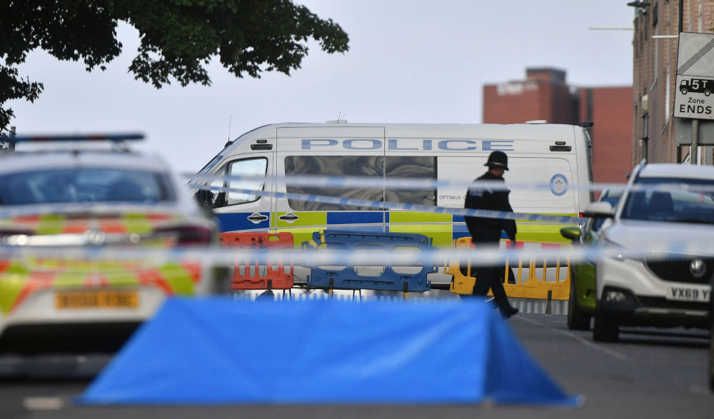 A police officer and vehicles are seen at a cordon in Irving Street in Birmingham after a number of people were stabbed in the city centre, Sunday, Sept. 6, 2020. British police say that multiple people have been injured in a series of stabbings in a busy nightlife area of the central England city of Birmingham.(Jacob King/PA via AP)