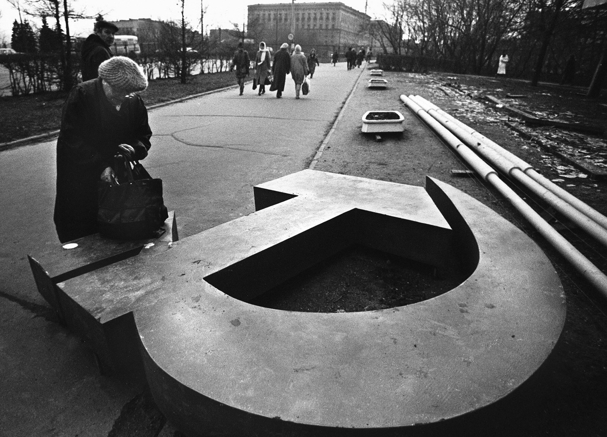 A woman reaches into her bag, which rests on a fallen Soviet hammer-and-sickle on a Moscow street in 1991. December 25, 2011 will mark the 20th anniversary of the fall of the Soviet Union.