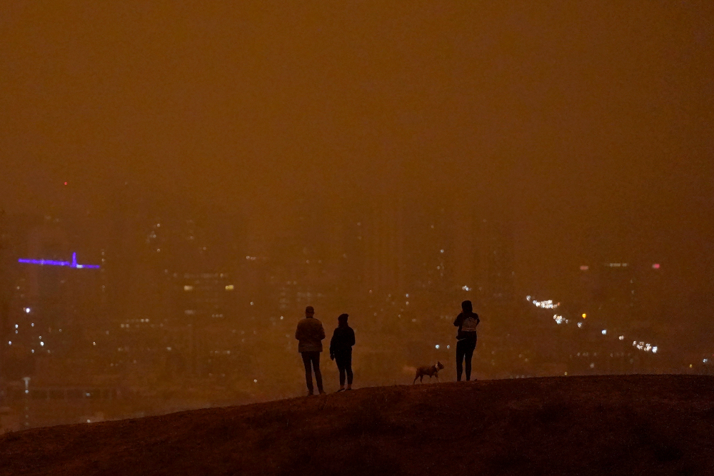 People look toward the skyline obscured by wildfire smoke in daytime from Kite Hill Open Space in San Francisco, Wednesday, Sept. 9, 2020. (AP Photo/Jeff Chiu)