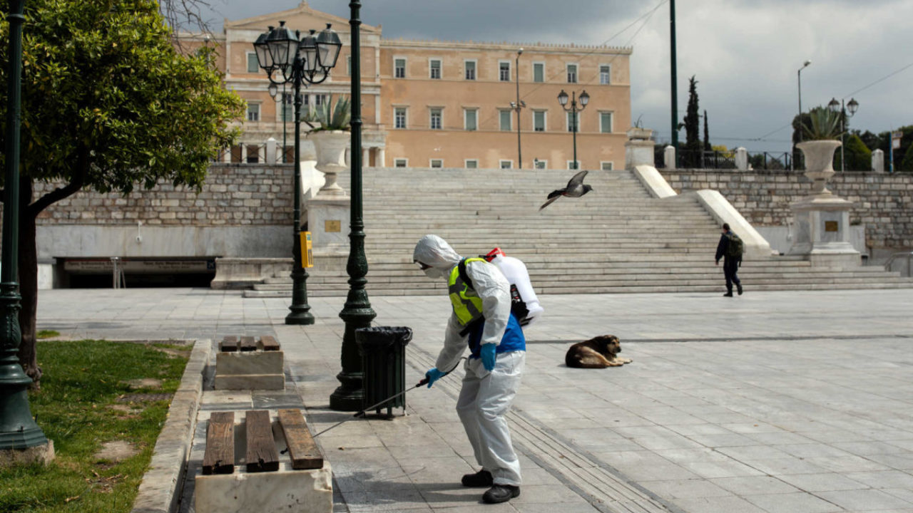 A municipal worker wearing a protective suit disinfects Syntagma square, after the Greek government imposed a nationwide lockdown to contain the spread of the coronavirus disease (COVID-19), in Athens, Greece, March 23, 2020. REUTERS/Alkis Konstantinidis