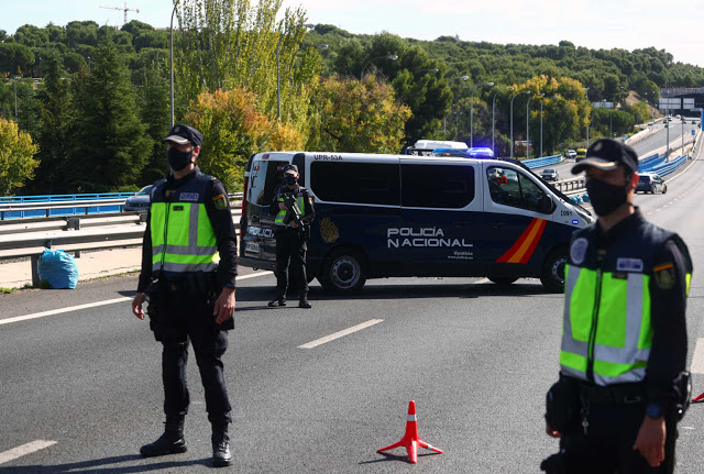 FILE PHOTO: Spanish National Police officers wearing protective masks stand at a traffic checkpoint during a partial lockdown amid the outbreak of the coronavirus disease (COVID-19), in Madrid, Spain October 5, 2020. REUTERS/Sergio Perez/File Photo