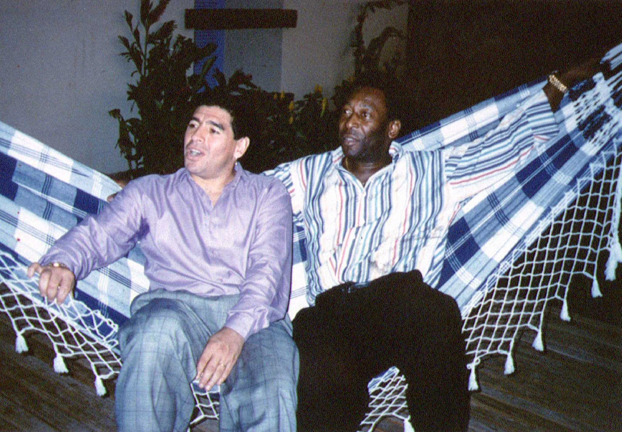 FILE PHOTO: Soccer legends Diego Maradona (L) and Pele rest on a hammock during a reception in Rio de Janeiro, May 14, 1995.  REUTERS/File Photo