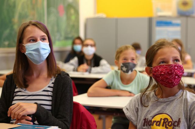 Schoolgirls of the fifth year voluntarily wear protective face masks inside their classroom as schools re-open after summer holidays and the lockdown due to the outbreak of the coronavirus disease (COVID-19) at the Karl-Rehbein high school in Hanau, Germany, August 17, 2020.   REUTERS/Kai Pfaffenbach