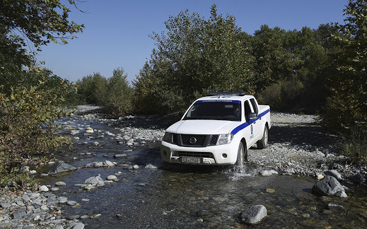 A Greek police truck crosses a river during a patrol at the Greek-Macedonian border near the northern Greek border station of Idomeni, on Monday, Oct. 3, 2016. Despite Macedonia's construction of a fence, dozens of people try to sneak across the border every day, hoping to make their way to Europe's prosperous heartland. Police have been detaining about 50 people daily, and arresting members of smuggling gangs that promise to get migrants to their destinations. About 60,000 refugees and other migrants are trapped in financially-struggling Greece. (AP Photo/Giannis Papanikos)