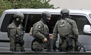 Police officers secure the High Regional Court in  Celle, Germany, Tuesday, Sept. 26, 2017. A suspected representative of the Islamic State group in Germany goes on trial in the northern city of Celle on terrorism charges. The 33-year-old Iraqi citizen and four fellow suspects are accused of membership in a terrorist organization, terror financing and public incitement to commit crimes. (Holger Hollemann/dpa via AP)