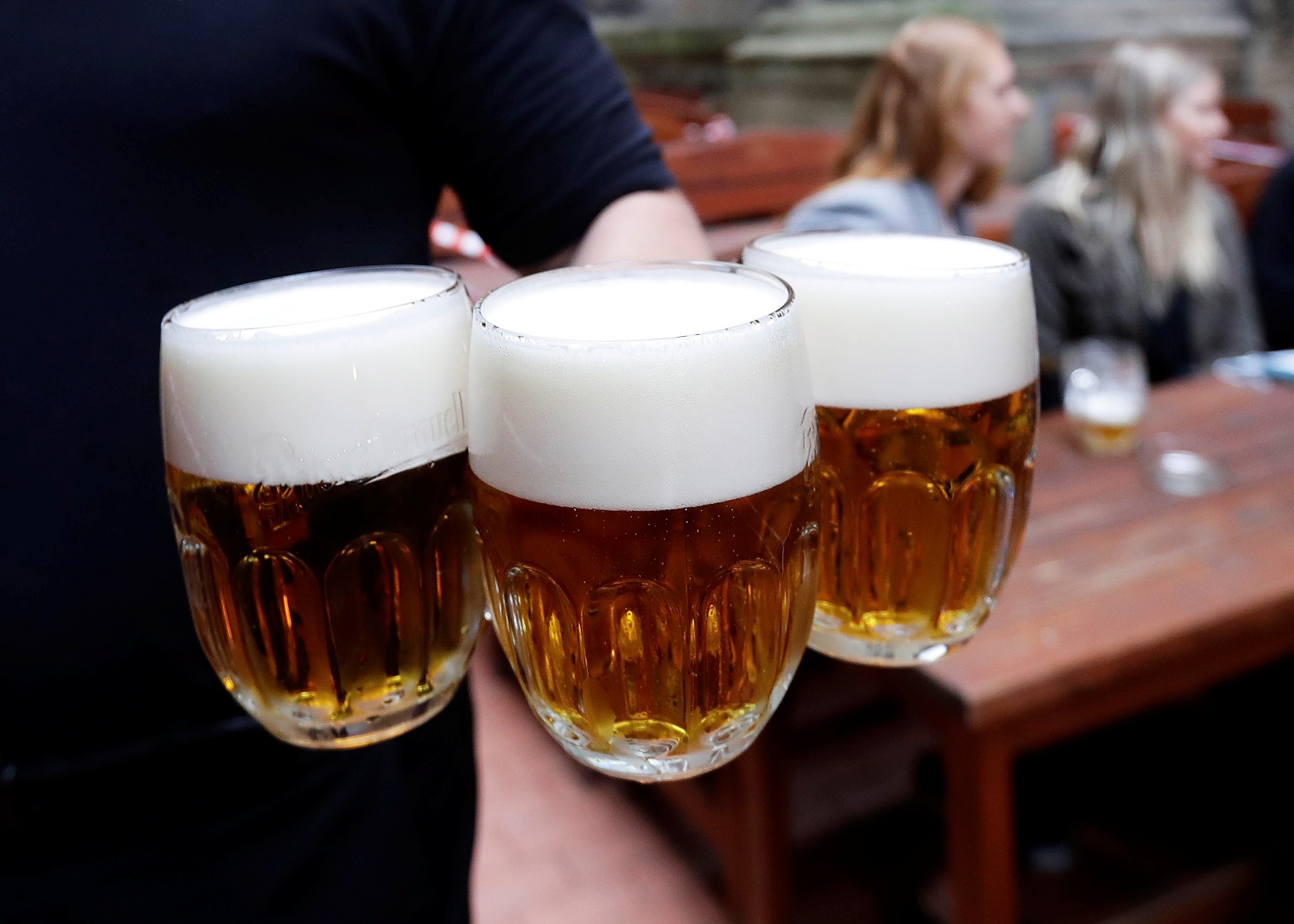 A bartender carries beers at an outdoor seating section of a pub, as the Czech government lifted more restrictions allowing restaurants with outdoor areas to re-open amid the coronavirus disease (COVID-19) outbreak, in Prague, Czech Republic, May 11, 2020.  REUTERS/David W Cerny
