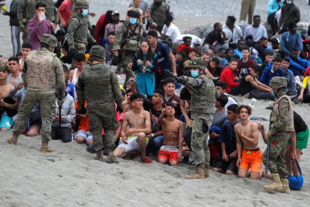 Spanish legionnaires regroup the minors at El Tarajal beach, near the fence between the Spanish-Moroccan border, after thousands of migrants swam across this border during last days, in Ceuta, Spain, May 18, 2021. REUTERS/Jon Nazca