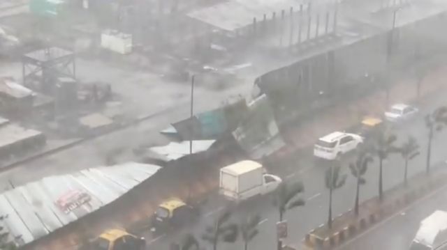 Winds and heavy rain knock down a metal wall due to Cyclone Tauktae in Wadala East, Mumbai, India May 17, 2021 in this screengrab obtained from a social media video. Courtesy PRANJITA BARMAN/via REUTERS THIS IMAGE HAS BEEN SUPPLIED BY A THIRD PARTY. MANDATORY CREDIT. NO RESALES. NO ARCHIVES.