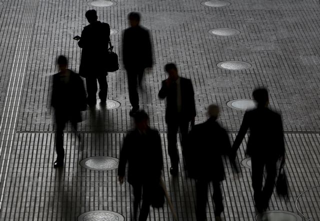 People walk at an office building at a business district in Tokyo, Japan, February 29, 2016. Japan's seasonally adjusted unemployment rate fell in January to 3.2 percent, data by the Ministry of Internal Affairs and Communications showed on Tuesday. Picture taken February 29, 2016. REUTERS/Yuya Shino TPX IMAGES OF THE DAY