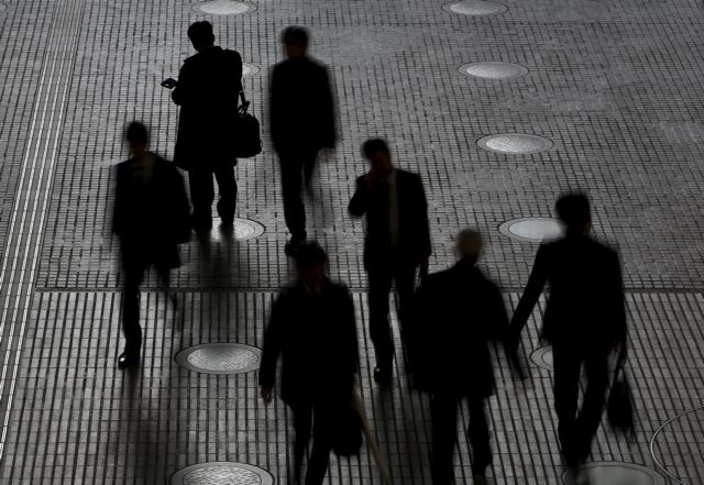 People walk at an office building at a business district in Tokyo, Japan, February 29, 2016. Japan's seasonally adjusted unemployment rate fell in January to 3.2 percent, data by the Ministry of Internal Affairs and Communications showed on Tuesday. Picture taken February 29, 2016. REUTERS/Yuya Shino      TPX IMAGES OF THE DAY