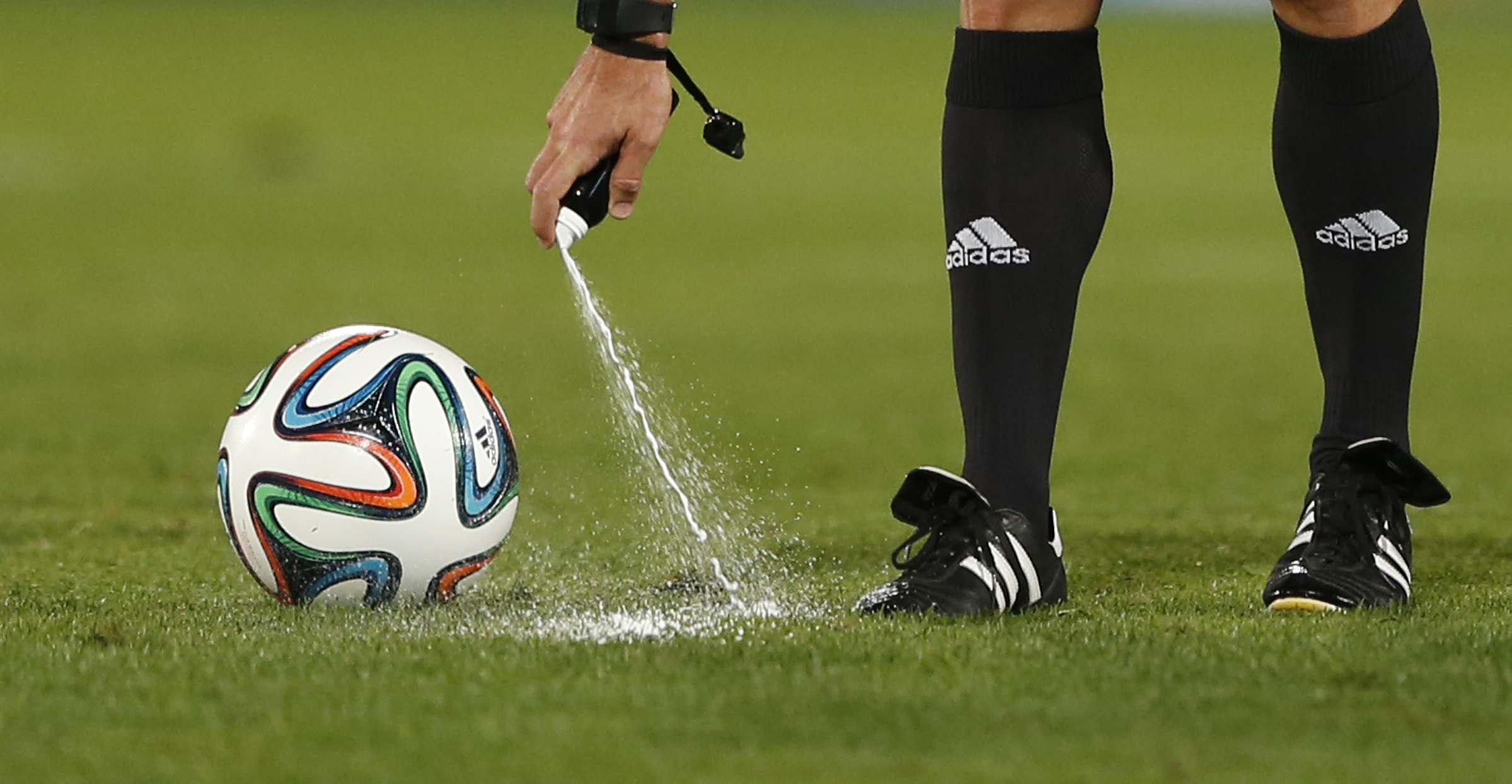 Referee Carlos Velasco of Spain marks a line with a spray during their semi final soccer match between Raja Casablanca and Atletico Mineiro at the Club World Cup soccer tournament in Marrakech, Morocco, Wednesday, Dec. 18, 2013. FIFA referees use vanishing spray to mark out the distance for a defensive wall from a free kick. The spray is popular in South America but is not widely used elsewhere. Vanishing spray is unlikely to be used at the World Cup in Brazil. (AP Photo/Matthias Schrader)