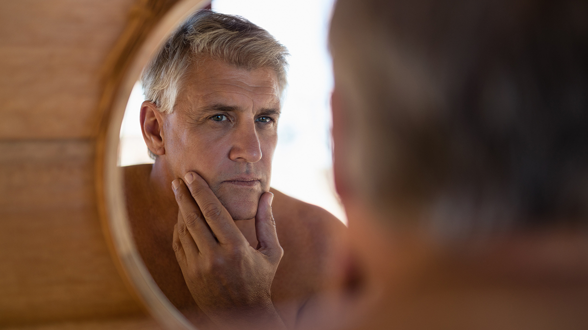 Man looking at mirror in cottage during safari vacation