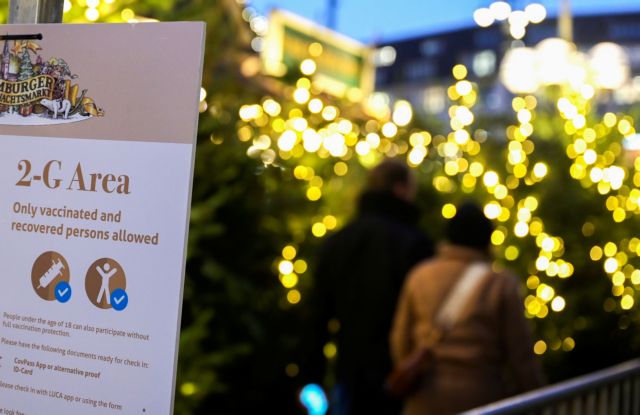 People wait at the entrance of a '2G' rule area at a Christmas market, allowing only those vaccinated or recovered from the coronavirus disease (COVID-19) to enter, in Hamburg, Germany on November 22, 2021. REUTERS/Fabian Bimmer