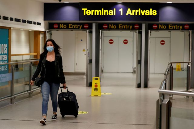 FILE PHOTO: A passenger wearing a face mask comes through the arrival terminal at Manchester Airport, following the outbreak of the coronavirus disease (COVID-19), Manchester, Britain, June 8, 2020. REUTERS/Phil Noble/File Photo