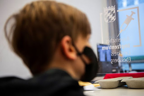 A boy waits to get children's dose of Comirnaty, the Pfizer-BioNTech vaccine against the coronavirus disease (COVID-19), at a vaccination centre in Ebersberg near Munich, Germany, December 15, 2021.REUTERS/Lukas Barth