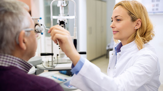Young female eye doctor determines eyes diopter using instruments in consulting room