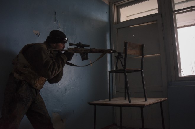 A fighter of the Azov Battalion holds his position in the town of Shyrokyne, eastern Ukraine, Sunday, March 22, 2015.  Government and Russian-backed separatist forces face off against one another across an unseen line cutting through the town in daily gun and artillery battles. The truce announced in mid-February never made it here. (AP Photo/Mstyslav Chernov)