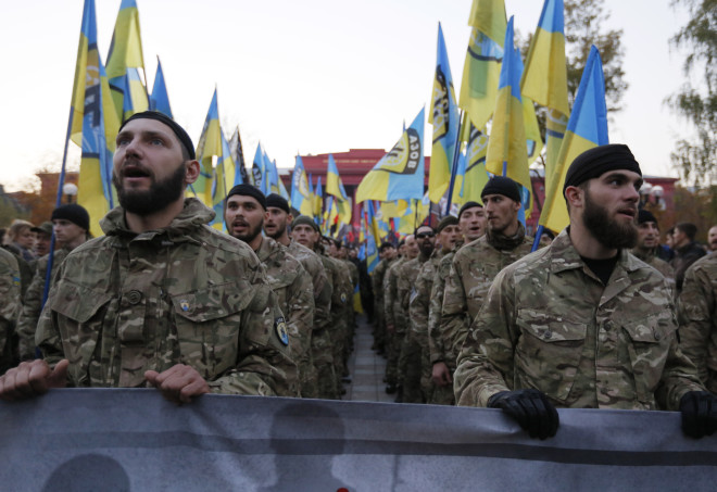 Fighters from the Azov volunteer battalion shout slogans during the march marking the 72nd anniversary of the Ukrainian Insurgent Army in Kiev, Ukraine, Tuesday, Oct. 14, 2014. The Ukrainian Insurgent Army initially collaborated with the Nazis, believing Hitler would grant Ukraine independence, but then went on to fight both Nazi forces and the Red Army. (AP Photo/Sergei Chuzavkov)