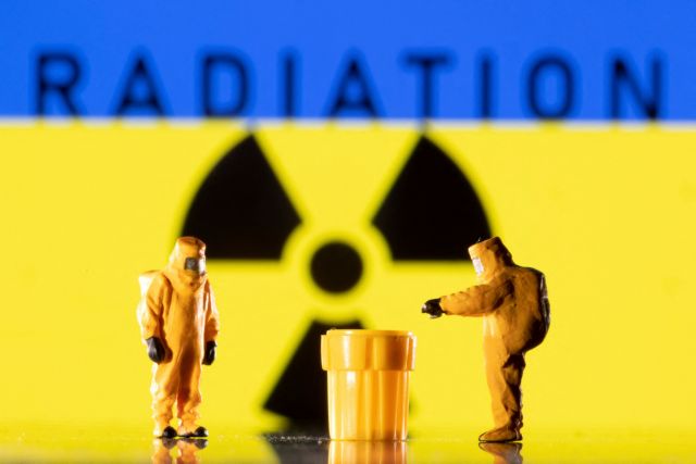 Figurines in protective equipments are seen in front of a displayed Ukrainian flag and a Radiation sign in this illustration taken March 9, 2022. REUTERS/Dado Ruvic/Illustration