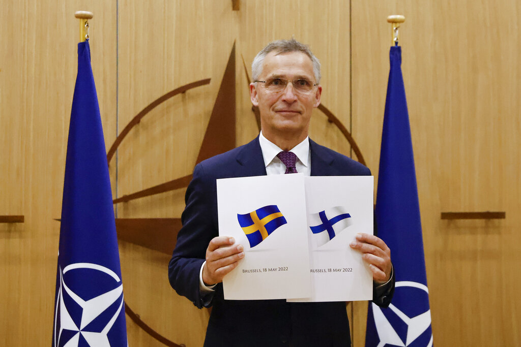 NATO Secretary-General Jens Stoltenberg displays documents as Sweden and Finland applied for membership in Brussels, Belgium, Wednesday May 18, 2022. NATO Secretary-General Jens Stoltenberg said that the military alliance stands ready to seize a historic moment and move quickly on allowing Finland and Sweden to join its ranks, after the two countries submitted their membership requests. (Johanna Geron, Pool via AP)