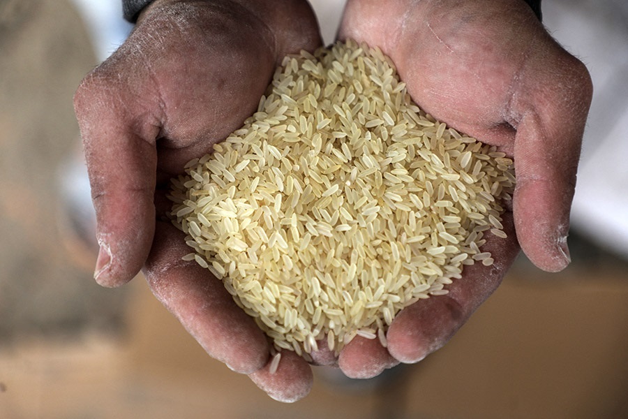 A Palestinian offers rice at a distribution center run by the United Nations Relief and Works Agency (UNRWA), in Gaza City, on March 16, 2022.- Russia's invasion of Ukraine could mean less bread on the table many cuntries in the Arab world where millions already struggle to survive. The region is heavily dependent on wheat supplies from the two countries which are now at war, and any shortages of the staple food have potential to bring unrest.
 (Photo by Majdi Fathi/NurPhoto) (Photo by MAJDI FATHI / NurPhoto / NurPhoto via AFP)