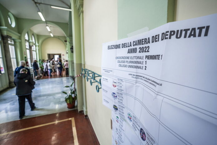 epa10205257 A candidate list (R) hangs on a wall during voting for the general election at a polling station in Turin, northern Italy, 25 September 2022. Italy holds a general snap election on 25 September following its prime minister's resignation in July. Final results are expected to be announced on 26 September.  EPA/JESSICA PASQUALON
