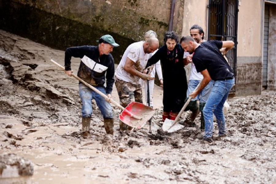 People help an elderly woman after heavy rains and deadly floods hit the central Italian region of Marche, in Cantiano, Italy, September 16, 2022. REUTERS/Yara Nardi     TPX IMAGES OF THE DAY