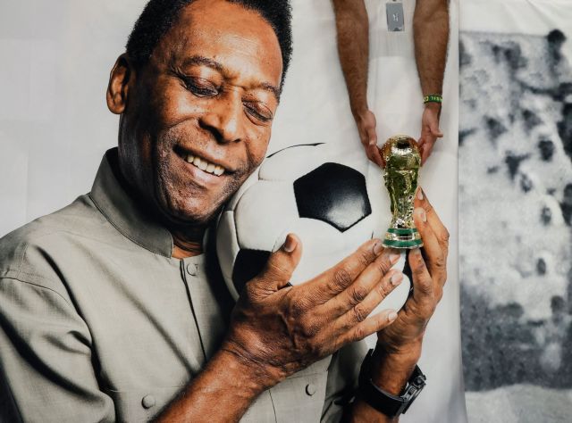 Soccer Football - FIFA World Cup Qatar 2022 - Group G - Cameroon v Brazil - Lusail Stadium, Lusail, Qatar - December 2, 2022 Brazil fan holds a replica World Cup trophy in front of a banner of former Brazil player Pele inside the stadium before the match REUTERS/Benoit Tessier     TPX IMAGES OF THE DAY