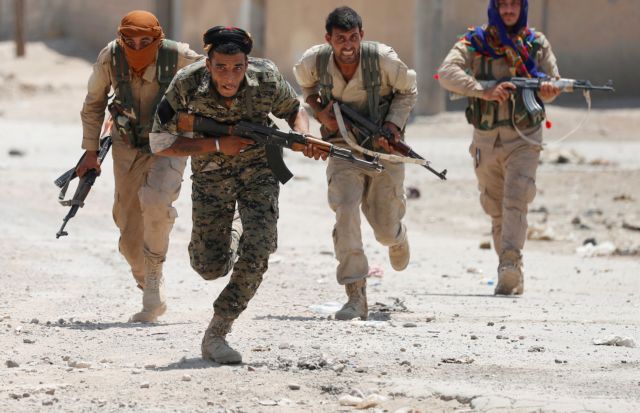 FILE PHOTO: Kurdish fighters from the People's Protection Units (YPG) run across a street in Raqqa, Syria July 3, 2017. REUTERS/Goran Tomasevic/File Photo