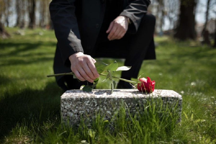man-bringing-rose-tombstone-cemetery-