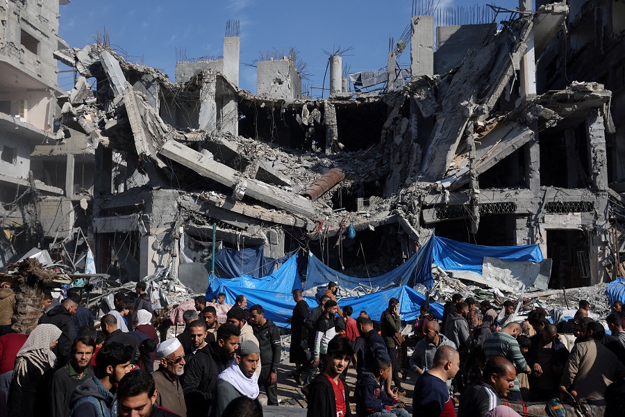 Palestinians shop in an open-air market near the ruins of houses and buildings destroyed in Israeli strikes during the conflict, amid a temporary truce between Hamas and Israel, in Nuseirat refugee camp in the central Gaza Strip November 30, 2023. REUTERS/Ibraheem Abu Mustafa