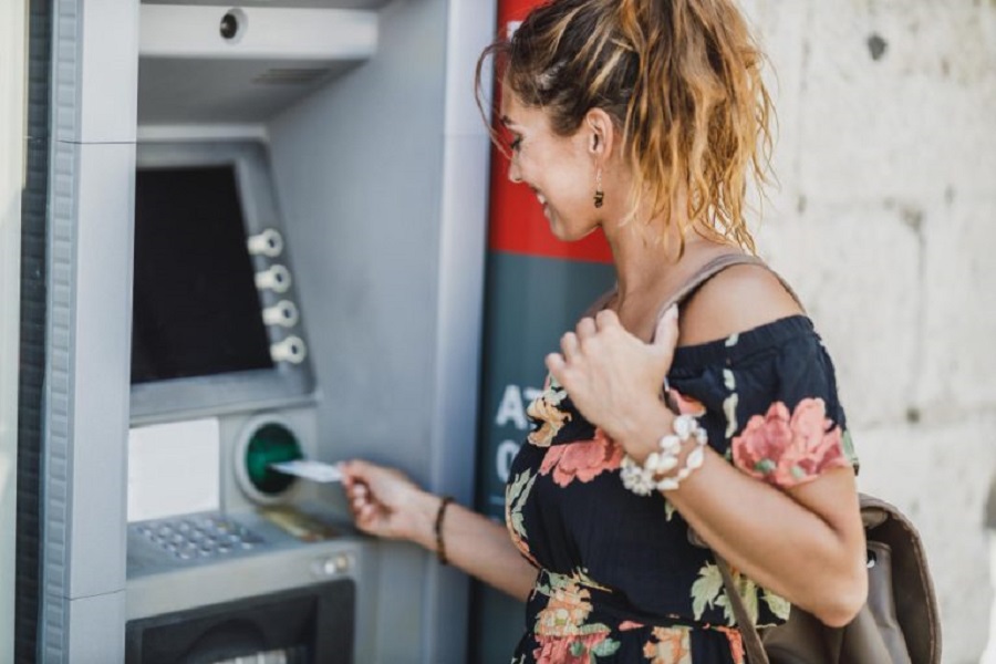 side-view-woman-inserting-credit-card-withdrawing-cash-atm-machine-