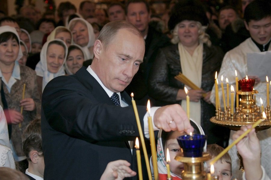 epa00608975 Picture made available Sunday 08 January 2006 of Russian President Vladimir Putin lighting a candle during Russian Orthodox Christmas celebrations on the eve of the holiday Friday 06 January 2006 in a cathedral in the Siberian city of Yakutsk. Orthodox Christians use the old Julian calendar and mark Christmas on 07 January.  EPA/ALEXEI PANOV/PRESIDENTIAL PRESS SERVICE/ITAR-TASS POOL