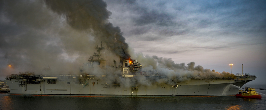 epa09378790 (FILE) - A handout file photo made available by the US Navy shows a fire continuing to be fought into the evening on board USS Bonhomme Richard (LHD 6) at Naval Base San Diego, in Sand Diego, California, USA, 12 July 2020 (issued 30 July 2021). According to a statement released by the US Navy on 29 July 2021, under the Uniform Code of Military Justice (UCMJ) the US Navy has filed charges against a Navy Sailor in response to evidence found during the criminal investigation into the fire started on USS Bonhomme Richard (LHD 6) on 12 July 2020. The Sailor, whose name has not been publicly revealed and was a member of the Bonhomme Richard's crew at the time, is accused of starting the fire.  EPA/US NAVY/MC2 AUSTIN HAIST HANDOUT  HANDOUT EDITORIAL USE ONLY/NO SALES