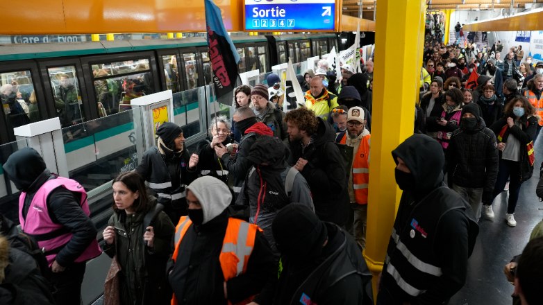 Striking railway workers invade a subway station as they head for a protest, Thursday, April 13, 2023 in Paris. French unions are staging a new round of nationwide protests, on the eve of an expected ruling by a top constitutional body that they hope will derail President Emmanuel Macron's unpopular pension reform plan. (AP Photo/Lewis Joly)